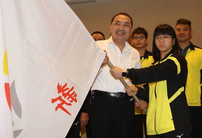 新北市长侯友宜（左）19日出席市政会议前，为中等学校运动代表队授旗。（陈君玮摄）