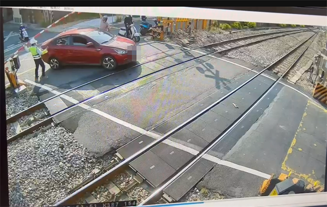 平交道保全员和路过骑士赶紧协助将遮断杆抬起。（翻摄照片／高雄洪靖宜传真）