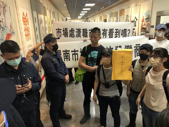 开会途中碰上摊商聚集在场外，要求进场参与会议。（张芷瑜摄）