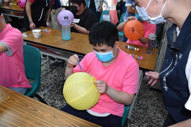 头份566慢飞天使们聚精匯神地彩绘灯笼来参加头份4月8活动。（谢明俊摄）