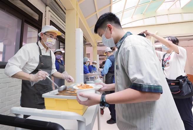 謝國樑親自幫同學夾菜。（基隆市政府提供／徐佑昇基隆傳真）