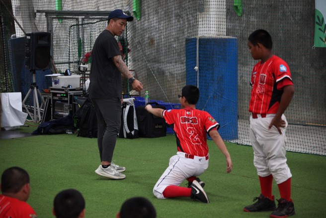 郭泓志（左）与小球员进行基础反应训练。（台湾世界少棒联盟提供）