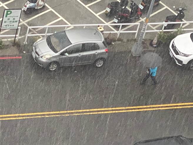 中央气象局针对彰化发布大雷雨警报，民眾在雨中撑伞步行。（孙英哲摄）