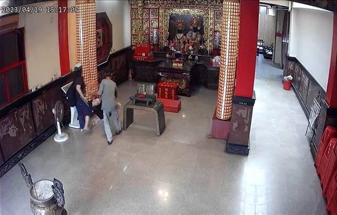 陈、杨两嫌合力搬走庙中功德箱。(警方提供／曹婷婷台南传真)