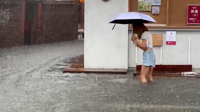 鹿港老街又淹水，一名女子冒險涉水。（民眾提供／孫英哲彰化傳真）