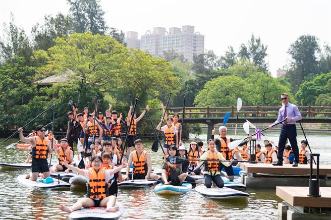 清大校长高为元（右）授桨给在成功湖试划的学生。（清大提供／王惠慧新竹传真）