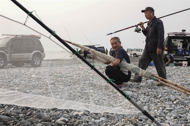 捕鱼苗人作业结束后立即忙着整理渔具。（黄子明摄）