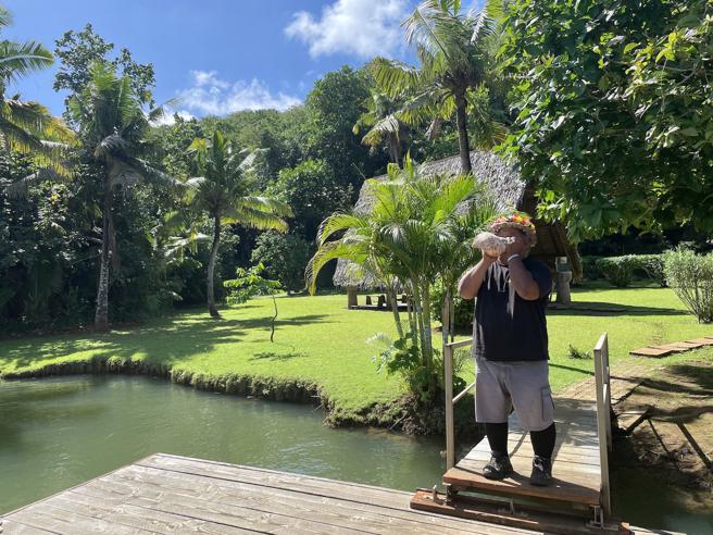 村民在岸边吹响号角，欢迎游客到访。（何书青摄）