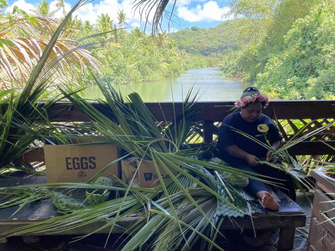 在地人现场将椰子树叶编织出各式用品。（何书青摄）