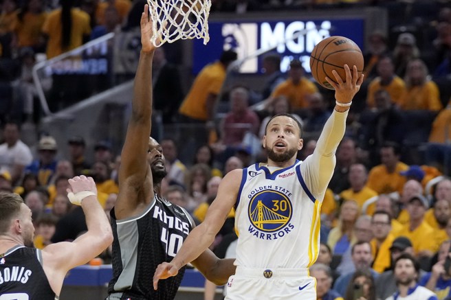 柯瑞闪过哈里生巴恩斯的防守上篮取分。(美联社)