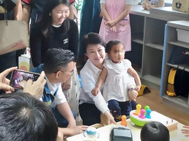 台中市長盧秀燕（右2）24日出席「北屯舊社托嬰中心」開幕儀式，視察時托嬰中心孩子主動跑來討抱，場面溫馨。（潘虹恩攝）