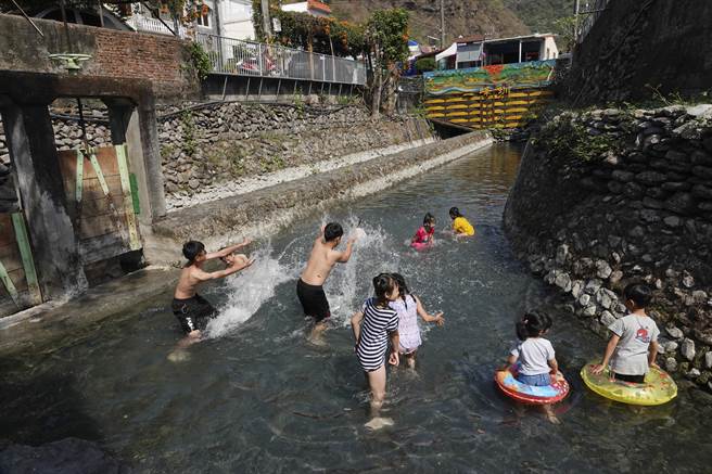 屏东来义乡二峰圳侧向溢流堰支流亲水区，水位虽然略为下降，仍有近40公分深度，足够让民眾泡水消暑。（黄子明摄）