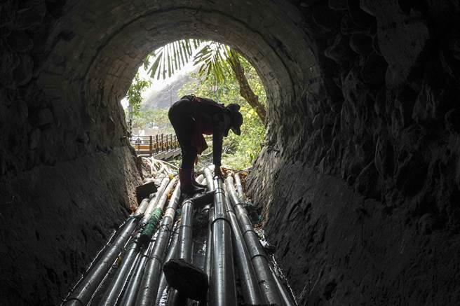 屏东来义乡新来义部落的罗姓老农妇发现田里无水可用，前往二峰圳主河道水管取水口查看并修復漏水水管。（黄子明摄）