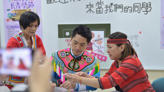 蒋万安穿针引线在小方格棉布中绣出八角星图腾，考验眼力与手部灵活度。(台北市原民会提供)