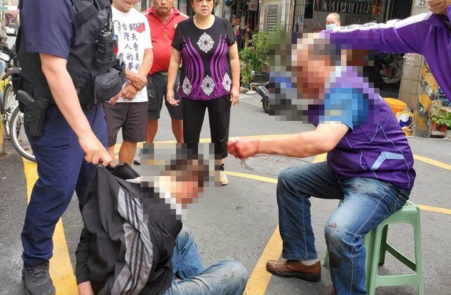 高雄市凤山区镇北里长赵志成今（25）日早上走出服务处，竟然遭到两名歹徒持铁棍突袭，赵男当场溅血，其中1人被压制逮补，另1人趁乱逃亡，警方全力追捕中。（柯宗纬翻摄）