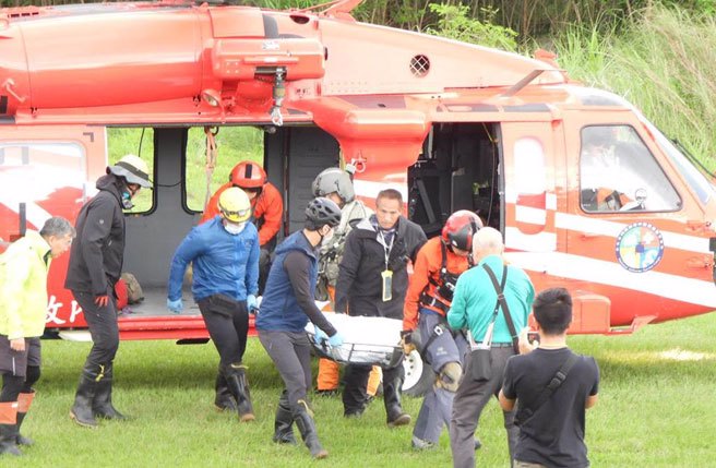 空勤总队直升机今将不幸殒落山林的陈男遗体吊挂下山。（罗亦晽摄）
