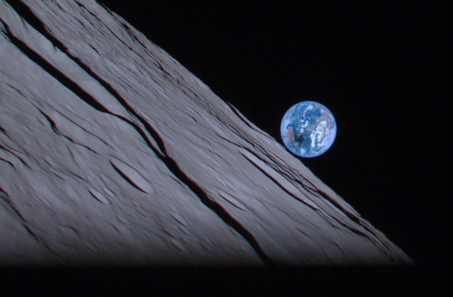 白兔号绕行月球，拍到了一张「地球升」的照片，可注意到地球有块暗斑，那是因为当地正在发生日食，暗斑是月球的阴影。(图/iSpace)