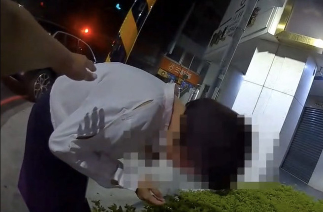 该对情侣喝茫酒驾在派出所前路中央睡着 ，警猛拍窗喊「太离谱啦」。(戴志扬翻摄)