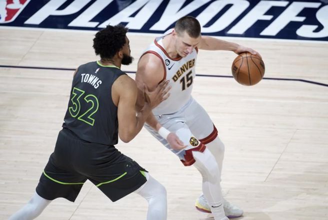 金块中锋约基奇(右)持球对抗灰狼唐斯。（美联社）