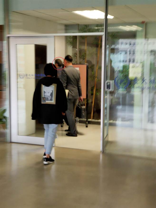 前國安局長陳明通（圖中已紅圈圈標示處）今（26）日下午1點10分左右現身台大社科院，出席教評會，步入會議室時，本報記者現場發問「是否來捍衛自己的退休金」、「把台大名聲搞臭怎麼回應」，陳明通不發一語，並在院方行政人員保護下，快速步入會場。（李侑珊攝）