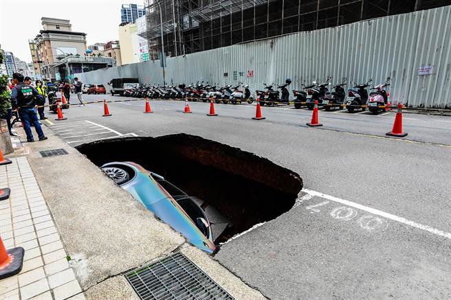 庄敬六街出现天坑，1辆特斯拉轿车掉进坑内，县府已展开调查路基下陷原因。（罗浚滨摄）