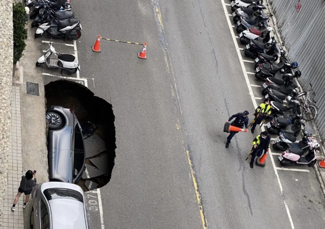 新竹县竹北庄敬六街「丰采520」建案疑因失误挖地下室，造成地下水掏空路基，形成巨大天坑，当场让停路旁的特斯拉整辆落入坑中。（翻摄照片）