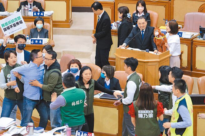 26日侯友宜施政报告，民进党议员戴玮姗（后排右）送上狒狒玩偶，绿营议员一拥而上，国民党议员王威元上前阻止，一度爆发拉扯。（资料照片/黄世麒摄）