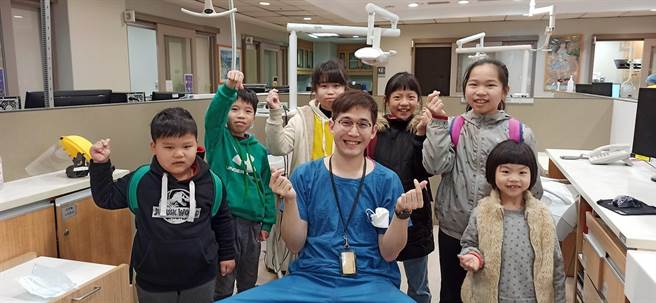 张伯森（中）的暖心态度，让6位小朋友放心团报看诊。（艾迪升传播提供）