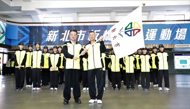 新北市教育局副局长刘明超（左）授旗予新北市「全国小学田径锦标赛」代表队，新埔国小校长陈维颖（右）代表接受。（新北市教育局提供）