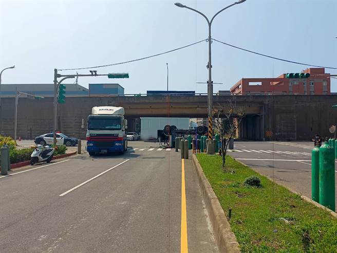 桃园货车驾驶遭大货车闯红灯撞翻四轮朝天，车上氮气钢瓶还外泄。（翻摄照片／蔡明亘桃园传真）