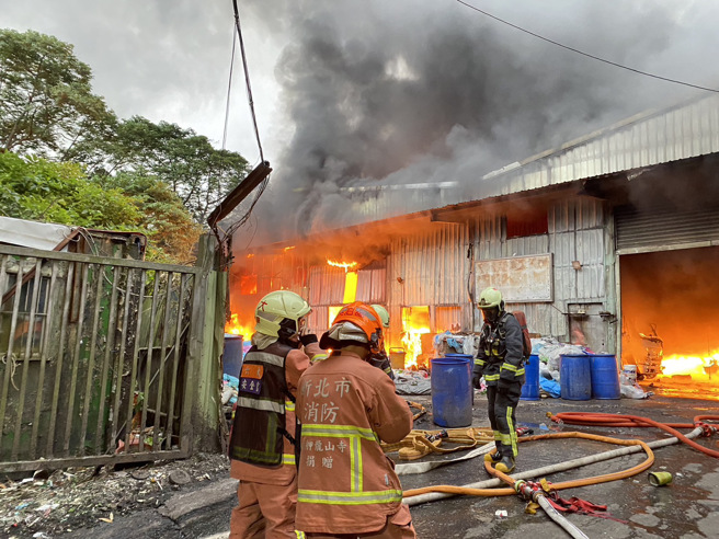 新北汐止鐵皮回收場大火，火勢猛烈黑煙急竄，延燒一旁竹林。(消防局提供)