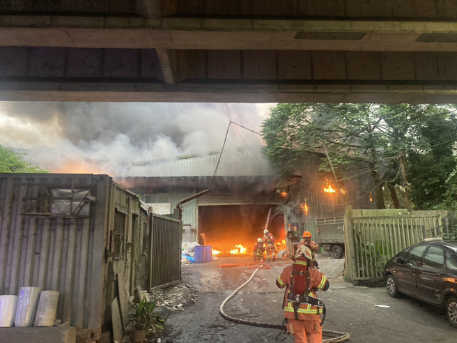 新北汐止鐵皮回收場大火，火勢猛烈黑煙急竄，延燒一旁竹林。(消防局提供)