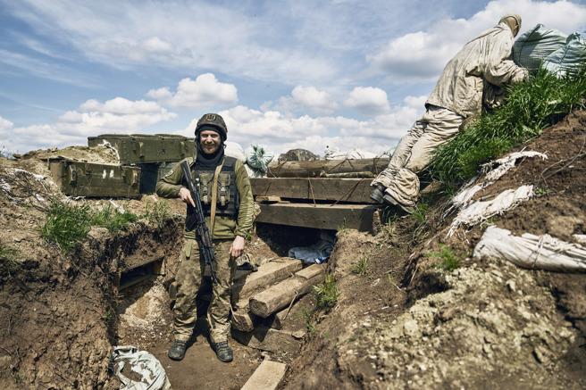 2023年4月24日，一名乌克兰士兵微笑着站在前线的战壕中。（美联社）