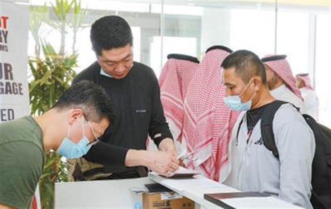 大陆从苏丹撤离中方人员部分乘包机返抵国门。图为在沙乌地吉达机场，中方工作人员为撤离同胞办理回国值机手续。（人民网）