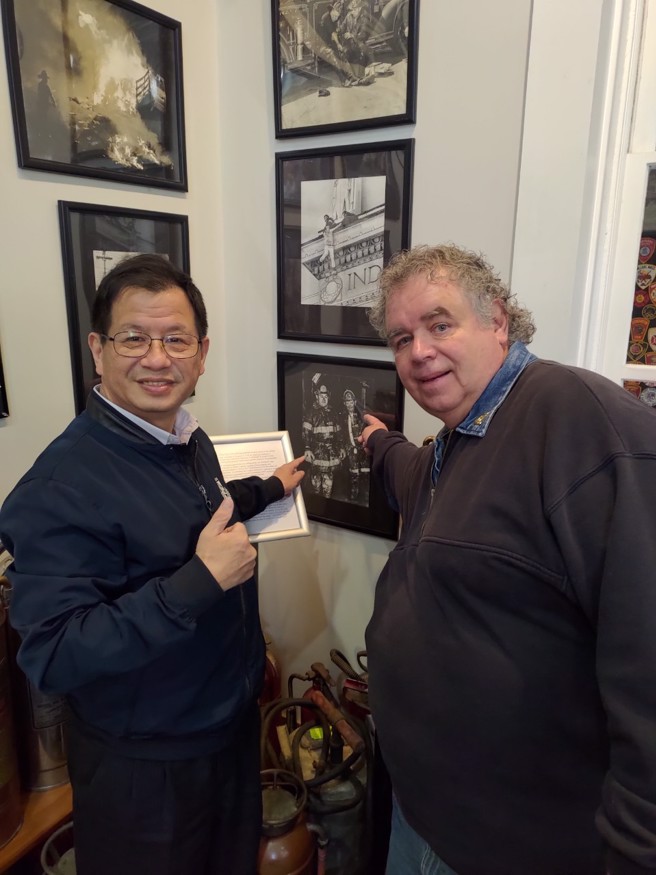 印第安纳波利斯消防博物馆退休人员利维斯除协助导览，并向陈崇岳展示其父亲担任消防人员期间的照片。(新北消防局提供)