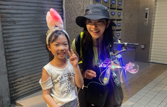 8岁女童以流利英文和企鹅妹对答，两人合照纪念。（蔡宛儒提供）