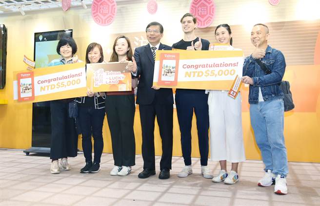 交通部长王国材（中）29日出席「游台湾金福气- Taiwan the Lucky Land」活动，并和幸运抽中5千元消费金的外籍观光客合影留念。（范扬光摄）
