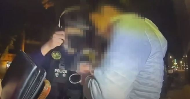 中年男遇警盘查竟「吞整包毒品」， 警急压制取出抢回一命。（翻摄自影片）