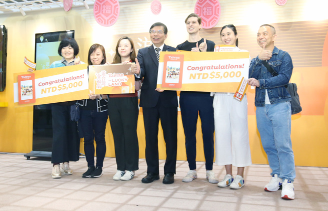 交通部长王国材（中）29日出席「游台湾金福气- Taiwan the Lucky Land」活动，并和幸运抽中5千元消费金的外籍观光客合影留念。（范扬光摄）