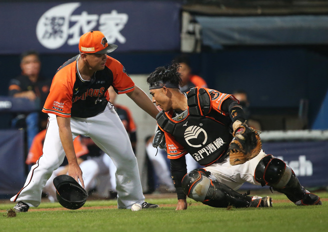统一狮捕手林岱安（右）处理软弱滚地球却不慎弄伤膝盖。（陈怡诚摄）
