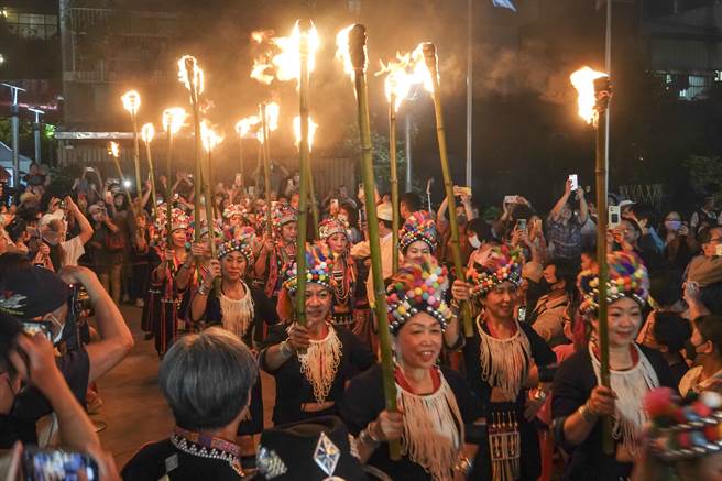 穿着云南少数民族服饰的妇女分持数十支火把进场。（黄子明摄）
