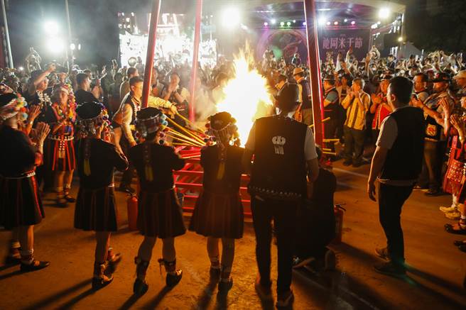 穿着云南少数民族服饰的妇女分持数十支火把进场，并把部分火把交给与会贵宾共同点燃篝火盆，熊熊烈火照亮现场。（黄子明摄）