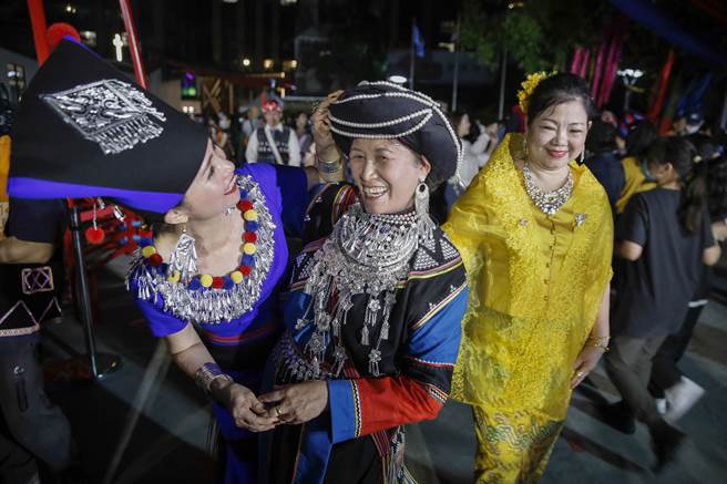 参加火把祈福活动后的妇女相拥打招呼。（黄子明摄）