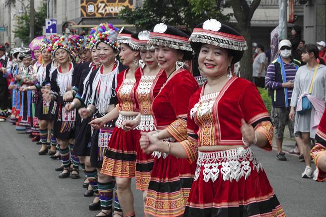 妇女穿上各民族传统族服参加踩街活动，沿路边走边跳舞。（黄子明摄）