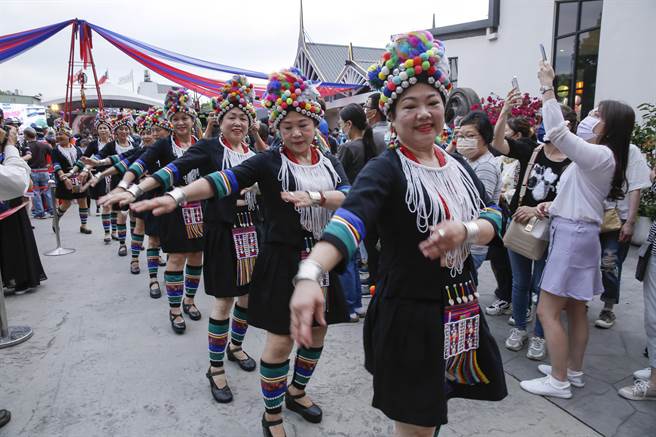 妇女穿上各民族传统族服参加踩街活动，沿路边走边跳舞。（黄子明摄）