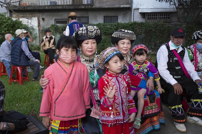 参加米干节的外地小朋友（前右、中）穿上当地民族传统族服，与龙冈少数民族妇女合影。（黄子明摄）
