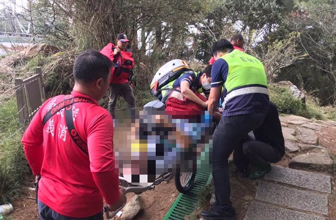 搜救人员到场后用人力背负轮式担架将张男送下山。（翻摄照片／张亦惠南投传真）
