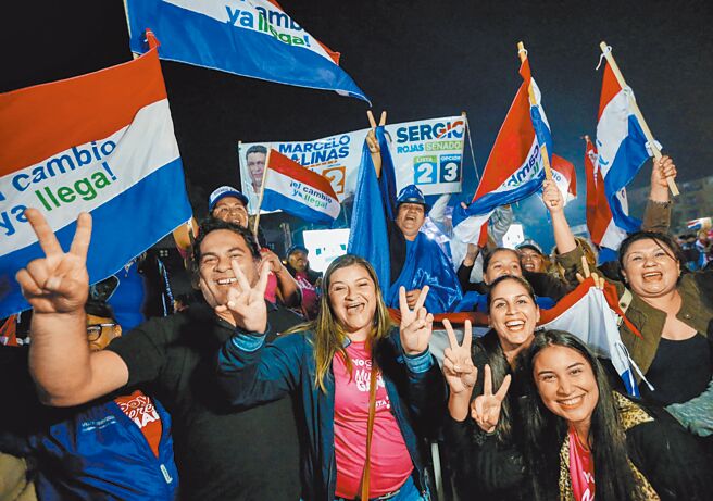 我国友邦巴拉圭4月30日举行总统、副总统及国会议员选举，友台的执政党国家共和联盟总统候选人贝尼亚获得近43％选票笃定当选，并已发表胜选声明。图为支持者在候选人造势集会上挥舞旗帜。（路透）