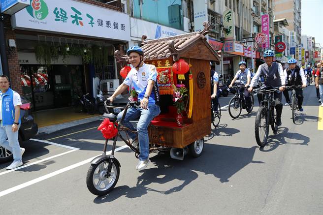 苗栗市长邱镇军骑乘「妈祖庙造型三轮车」。（李京升摄）