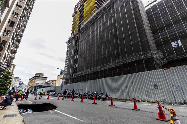 丰采520建案工地（右）用「逆打工法」开挖地下6层，疑428又造成庄敬六街「天坑 」，特斯拉轿车陷落坑内。（罗浚滨摄）